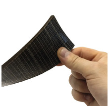 En hand håller en skiva av träkompositmaterial.