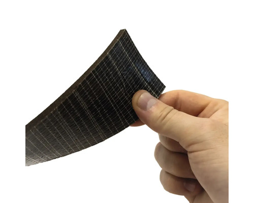 En hand håller en skiva av träkompositmaterial.