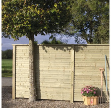 Trästaket med träd, blomkorg och trädgårdsredskap utomhus