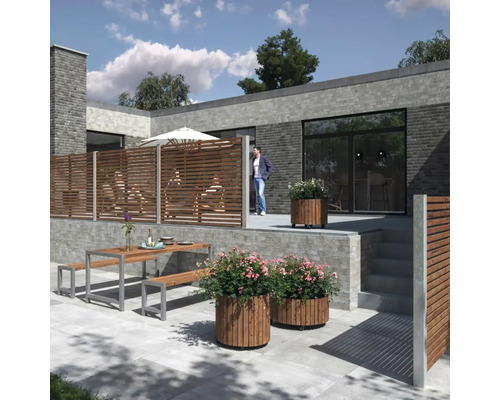 Terrass med träelement, blomlådor och sittgrupp framför ett modernt hus