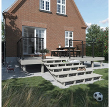 Terrass med trappa och bord framför ett hus