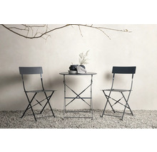 Trädgårdsscen med fällbord och två fällstolar på grusgolv