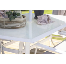 Detaljvy av ett trädgårdsbord med glasskiva, dekoration och parasollhållare