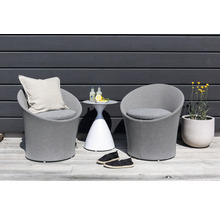 Miljöbild med två grå loungestolar, ett sidobord med drycker, skor och en blomkruka med gula blommor