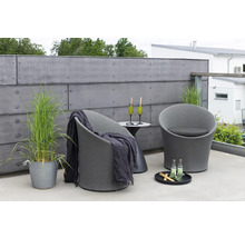 Terrassmiljö med två fåtöljer, sidobord, drycker och dekorativa element