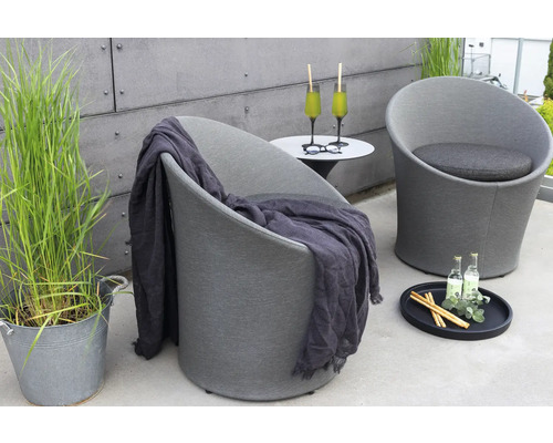 Miljöbild med två loungestolar, sidobord och utomhusdekoration.