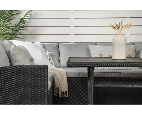 Närbild av en rottinggrupp med bord, kuddar och dekoration för utomhusbruk