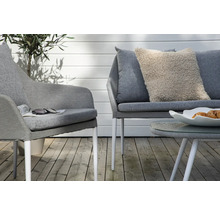 Scen med en grå fåtölj, en grå soffa, ett soffbord och en dekorativ kudde på en terrass