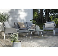 Uteplats med grå soffa, fåtöljer och ett bord med glasskiva för en mysig uteplats