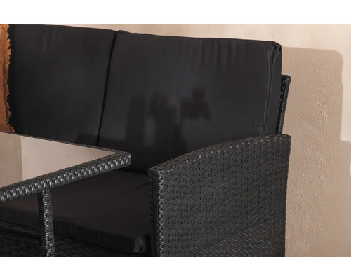 Närbild av en svart rottingträdgårdsbänk med bord