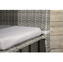 Detalj av en grå rottingfåtölj med sittdyna