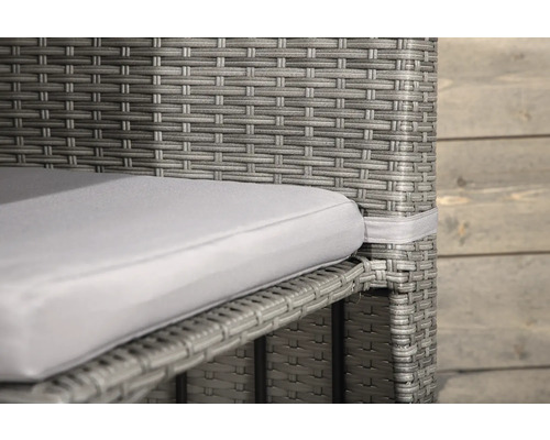 Detalj av en grå rottingfåtölj med sittdyna