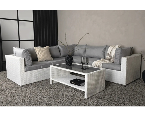 Trädgårdsscen med loungehörna, bestående av soffa och bord med glasskiva