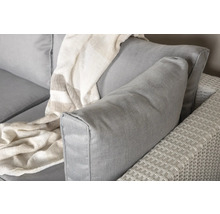 Detaljbild av en grå trädgårdssoffa med kuddar och en filt