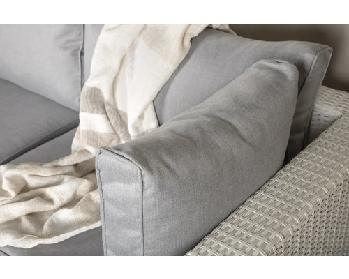 Detaljbild av en grå trädgårdssoffa med kuddar och en filt