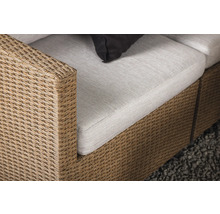 Detaljvy av en rottingsoffa med klädsel och kudde