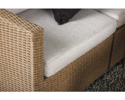 Detaljvy av en rottingsoffa med klädsel och kudde