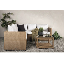 Trädgårdsscen med rottingsoffa, kuddar och soffbord