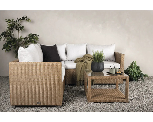 Trädgårdsscen med rottingsoffa, kuddar och soffbord