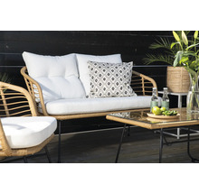 Trädgårdsmöbelset i rotting med bord, soffa och stol samt vita kuddar och dekoration