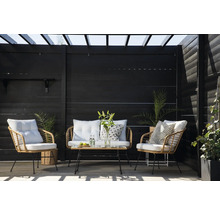 Terrassscen med rottingmöbler, bestående av två fåtöljer, en tvåsitssoffa och ett bord framför ett mörkt trästaket