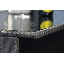 Detaljbild av ett trädgårdsbord med rottingstruktur och glasskiva