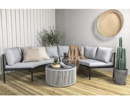 Trädgårdsscen med loungehörna, soffbord och dekorationer på en träaltan.