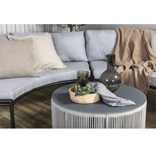 Miljöbild med trädgårdsmöbler, bestående av soffa, kuddar, bord, dekorationer och textilier för utomhusbruk