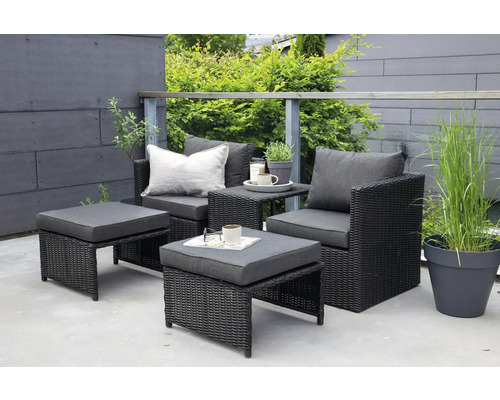 Utemöbelset med rottingfåtöljer, fotpallar och ett litet bord på en terrass