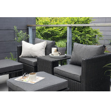 Trädgårdsmöbelset med fåtölj, bord och pall på en terrass