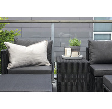 Terrass med rottinggrupp, kuddar, ljus, växt och kopp