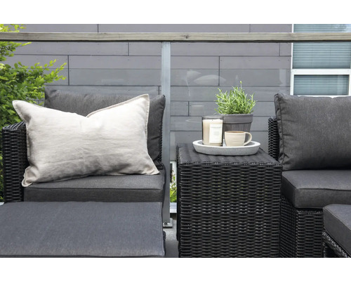 Terrass med rottinggrupp, kuddar, ljus, växt och kopp