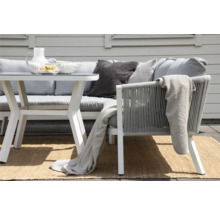 Trädgårdsmöbelset med bord, soffa och stolar på en matta utomhus