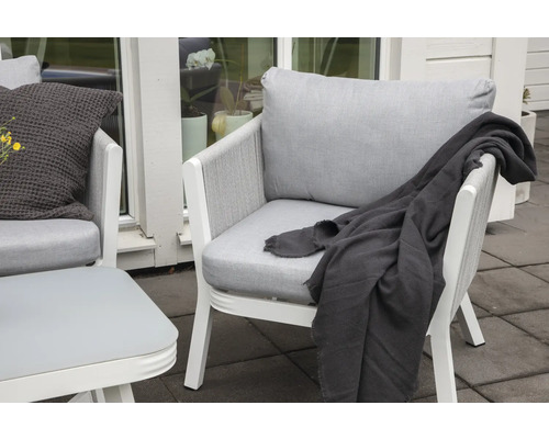 Två fåtöljer med kuddar och filt utomhus