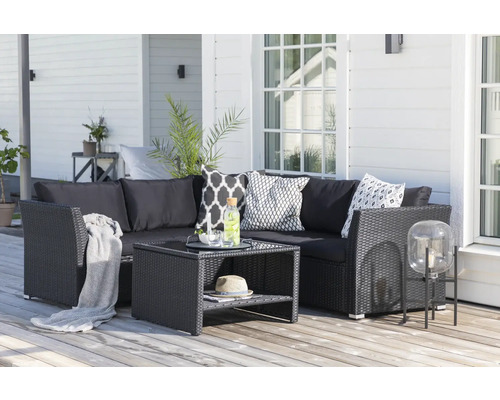 Trädgårdsloungegrupp i rotting med bord och kuddar på en träaltan