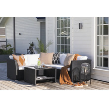 Terrass med loungemöbler, bord och dekorationer framför husfasaden