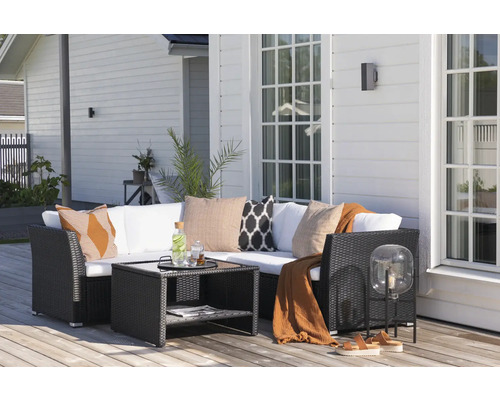 Terrass med loungemöbler, bord och dekorationer framför husfasaden