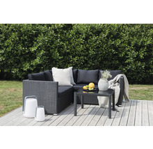 Trädgårdsmöbelset med hörnsoffa, bord och lyktor på en träterrass framför en grön häck