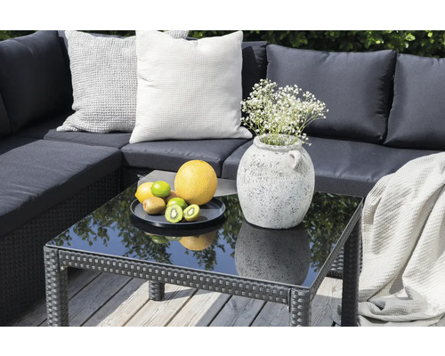 Trädgårdsgrupp med kuddar, bord med glasskiva, frukt och blomvas