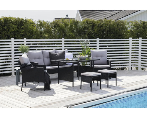 Trädgårdsmöbelset med soffa, fåtölj, bord och pallar på en terrass