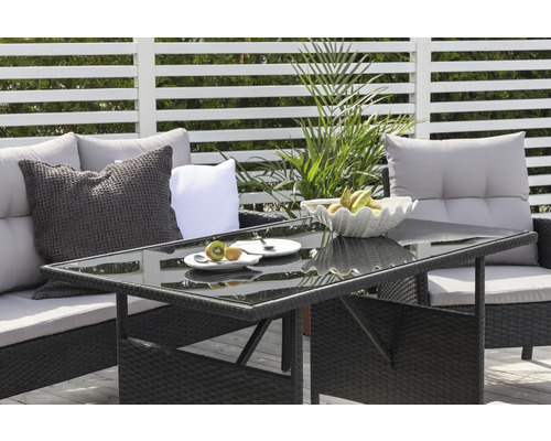 Terrassscen med sittgrupp och bord med glasskiva, dekorerad med frukt och porslin