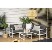 Trädgårdsscen med loungegrupp, soffbord och hängande rottinglampa framför insynsskydd