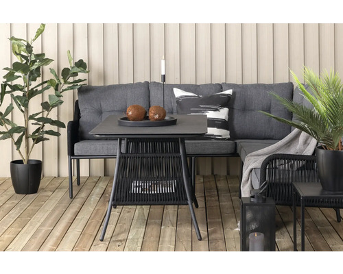 Trädgårdsscen med hörnsoffa, bord och växter på en träaltan