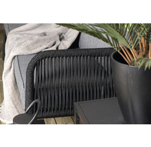 Detaljbild av en utomhusfåtölj med växter och sidobord