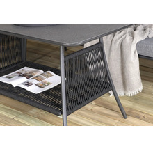 Detaljvy av ett trädgårdsbord med flätad hylla och tidning