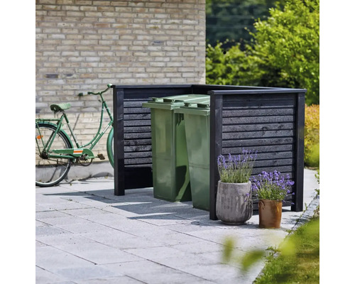 Synskydd för soptunnor med cykel i bakgrunden och blomkrukor i förgrunden