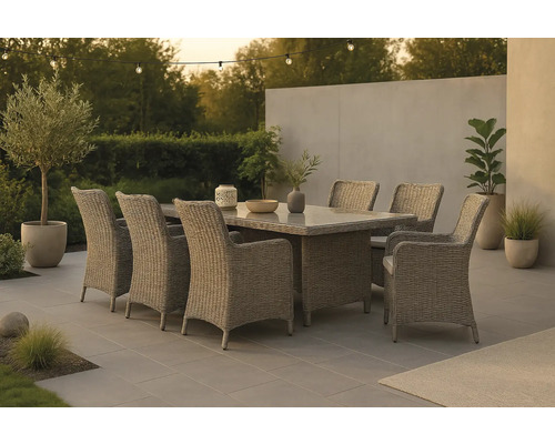 Trädgårdsscen med matbord och rottingstolar på en terrass med växter och belysning.