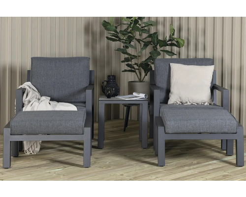 Två grå trädgårdsfåtöljer med sidobord och dekoration
