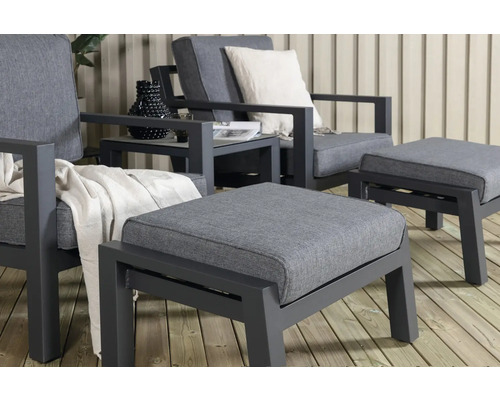 Trädgårdsmöbelset med fåtöljer och fotpallar på en terrass