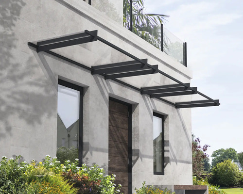 Modernt entrétak med mörk metallram och transparenta paneler ovanför ytterdörren och fönster på en grå stenfasad.